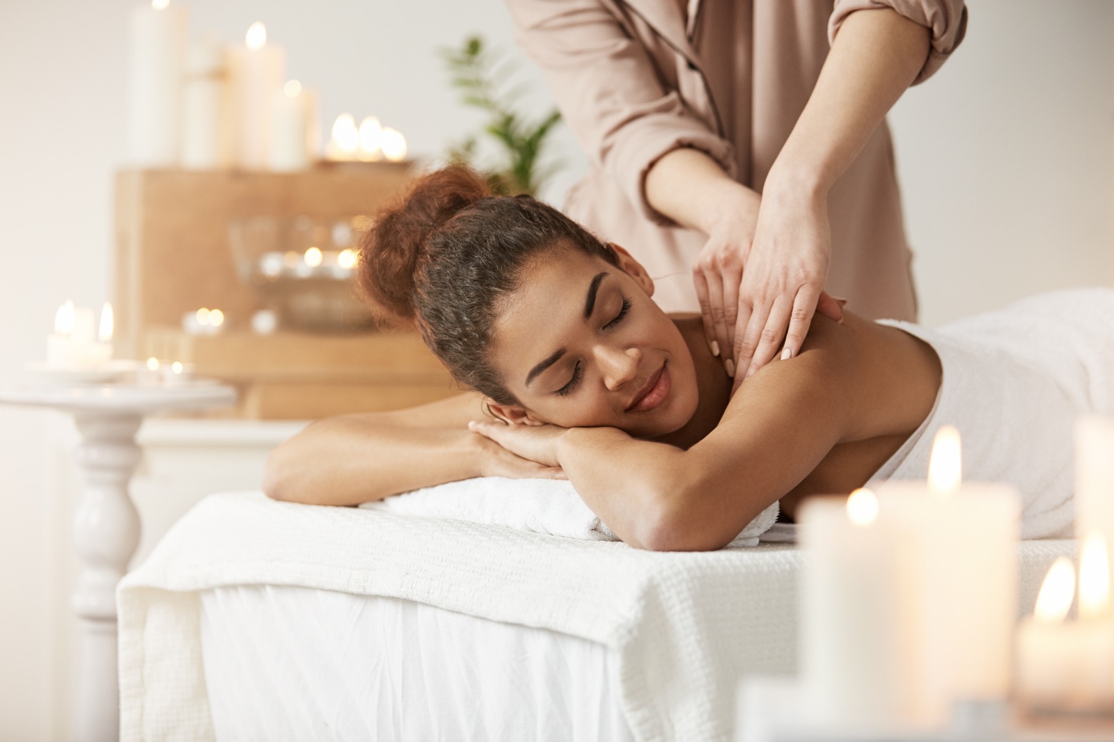 A 4K image focusing on a progression from basic to advanced massage techniques. It should be a split image showing a beginner's hand performing a simple technique versus an expert's hand utilizing a more advanced method. High-quality resolution emphasizes the detail and precision of the techniques. The contrast between simple and advanced helps to visualize progress. The lighting should be consistent between both parts of the image for easy comparison.